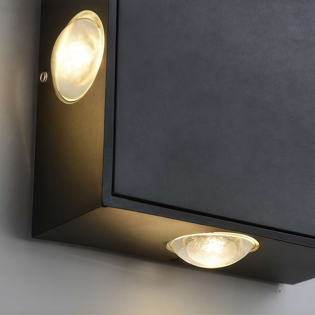 Minimalist black outdoor sconce light with glass shade chandelier design shown in close-up detail highlighting directional beam pattern.