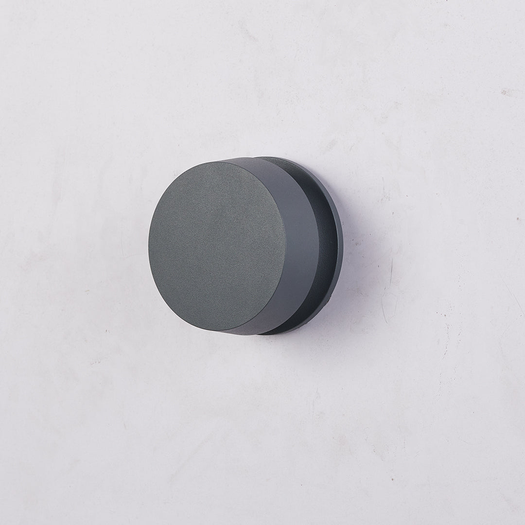 Minimalist black round LED path light providing discrete illumination for modern outdoor spaces