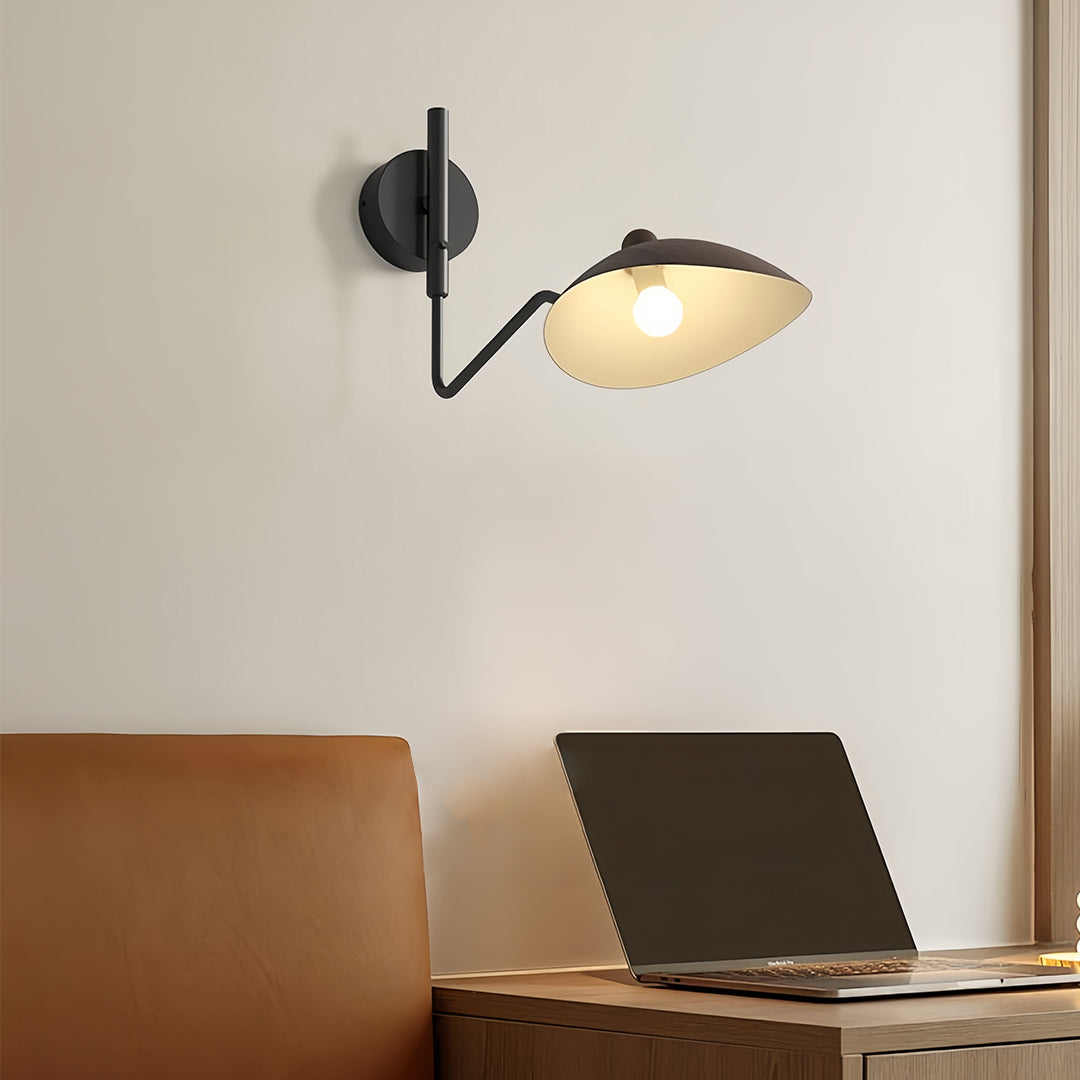 Minimalist black swing arm wall light with a single shade and long arm extension, ideal for flexible task lighting over a desk or console.