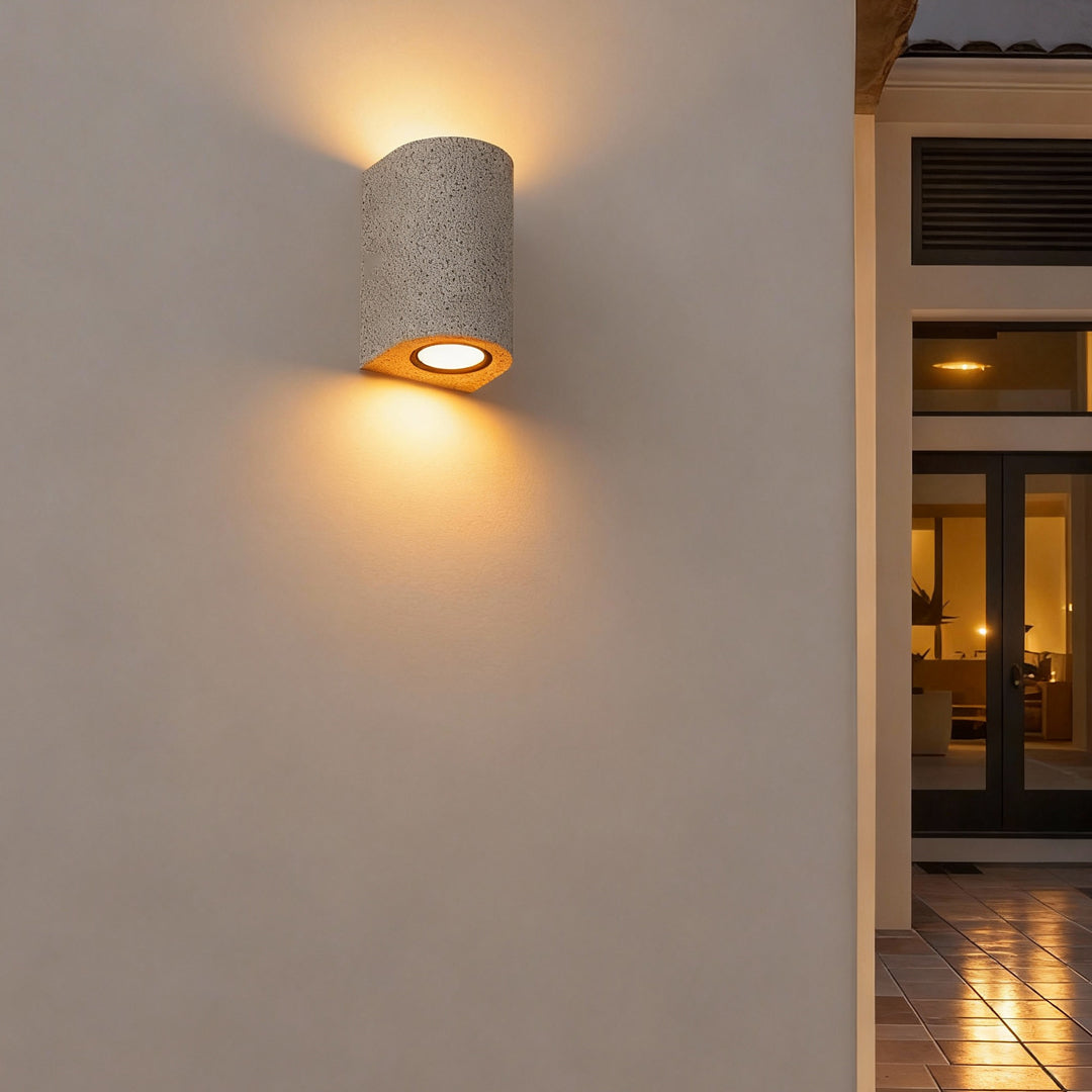 Minimalist cylindrical fixture producing warm up down wall lights on a clean exterior surface.
