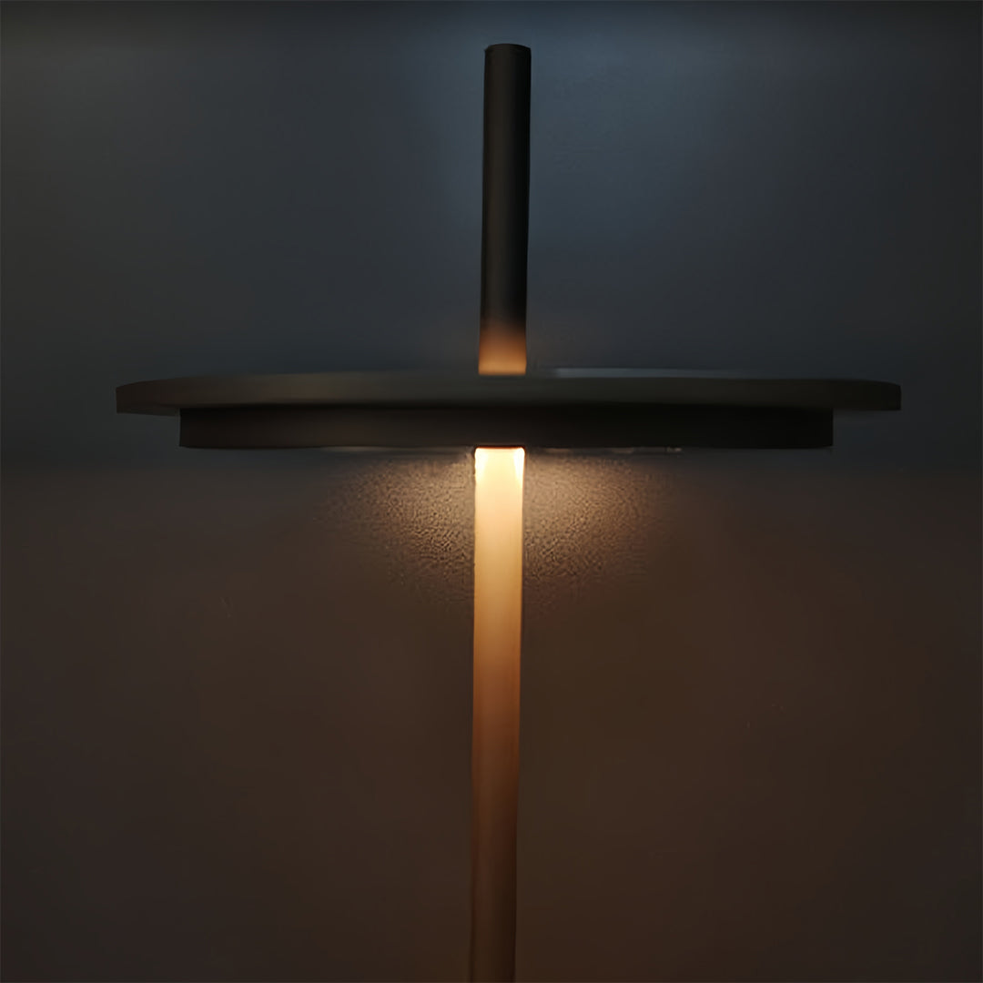 Minimalist dimmable table lamp creating ambient glow on dark wooden surface in contemporary space