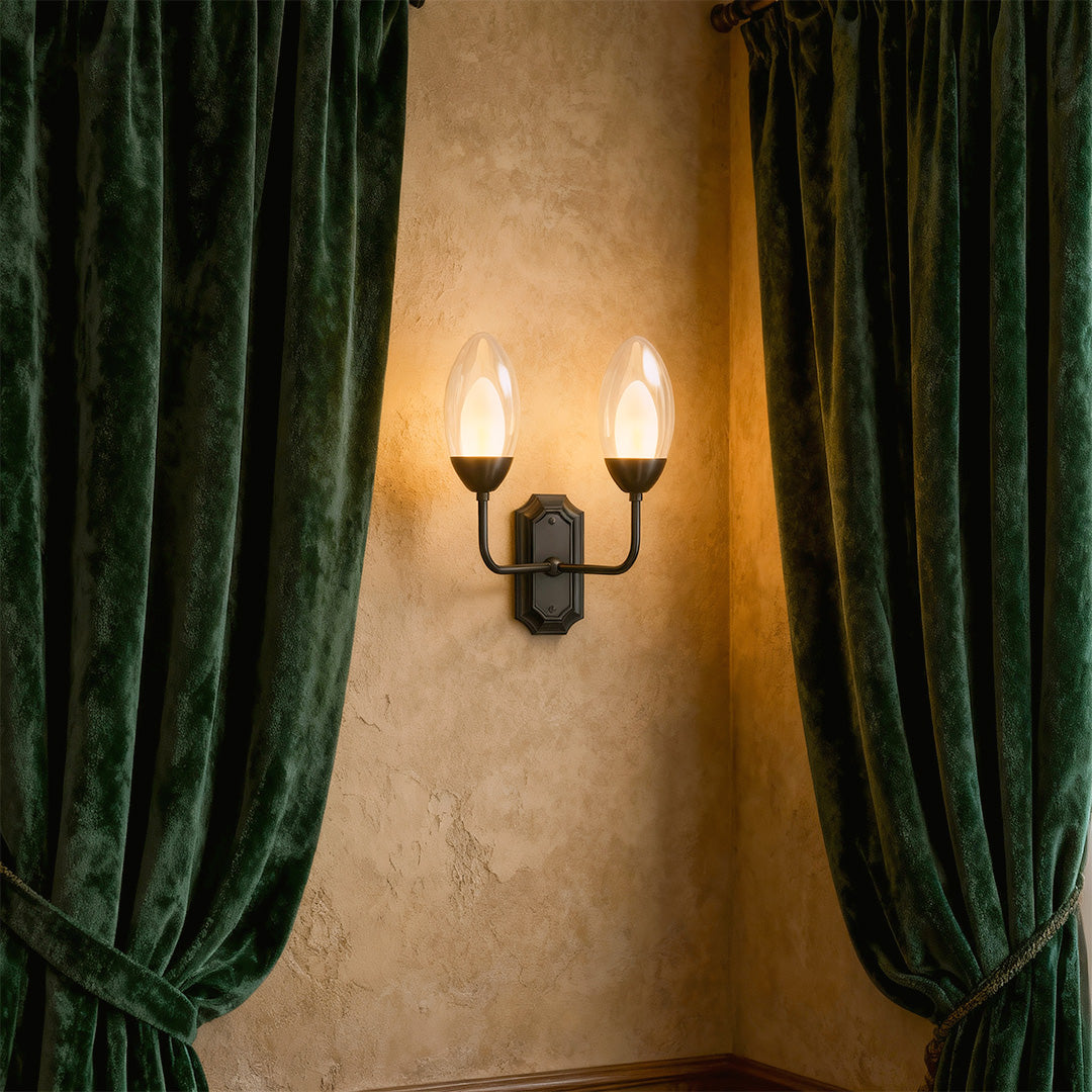 Minimalist glass wall light featuring glass shade chandelier design providing elegant illumination beside green velvet curtains.