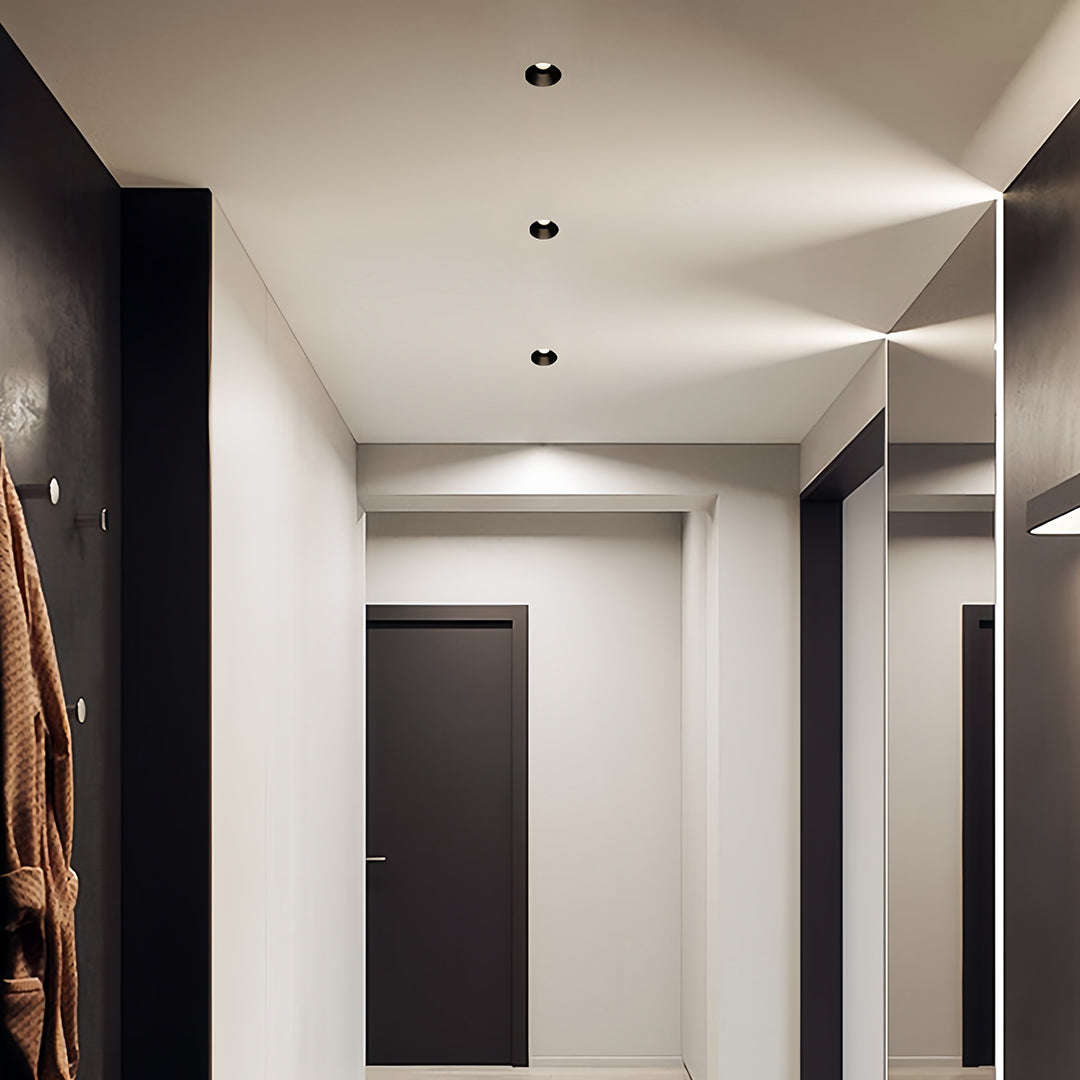 Minimalist indoor LED spotlight featuring glass shade chandelier aesthetic creating subtle ambient lighting in contemporary hallway.