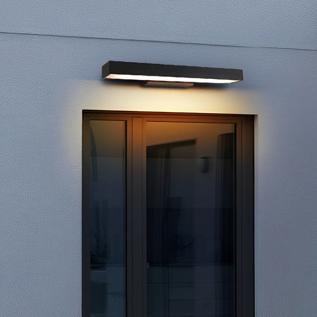 Minimalist led linear wall light mounted on a textured exterior wall, producing subtle downward light for modern outdoor spaces.