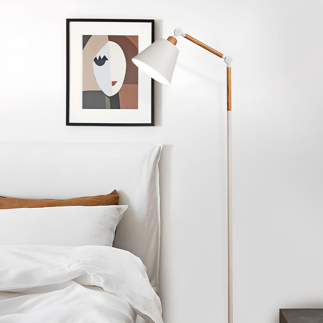 Minimalist metallic floor lamp with black shade and gold stem in modern office workspace setting