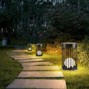 Minimalist outdoor lantern light featuring glass shade chandelier design illuminating garden pathway at twilight with warm ambient glow.