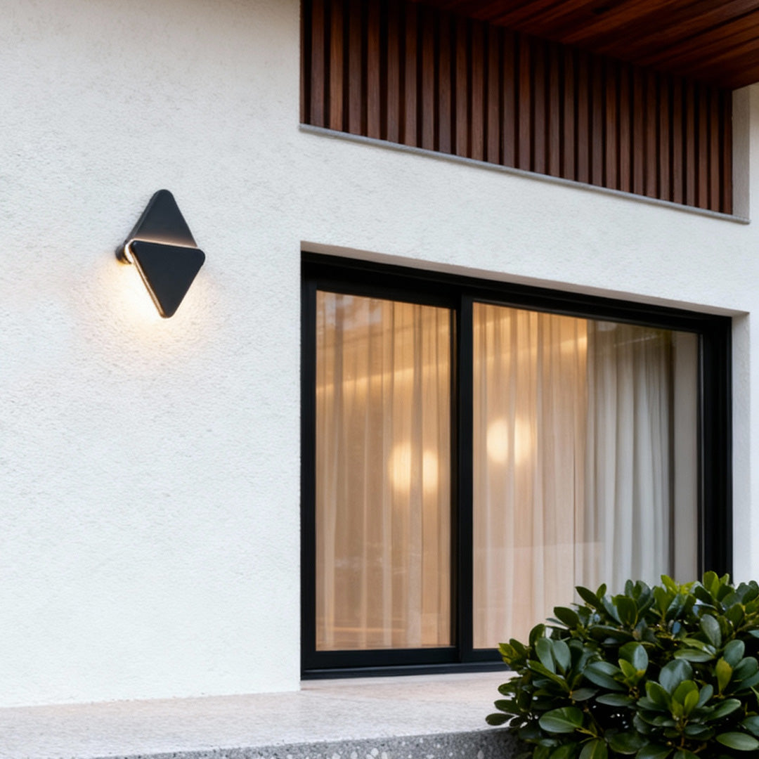 Minimalist outdoor lighting sconce on a clean white façade, casting soft illumination beside the large window.
