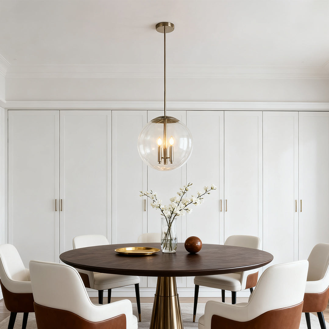 Glass orb pendant light suspended above a small, round dining table in a bright room with minimalist white paneling.