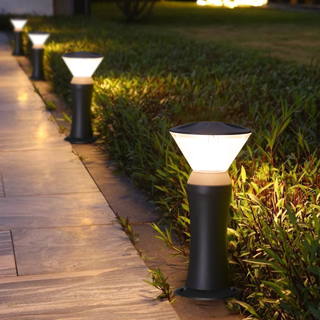 Pathway bollard lights providing guidance lighting along paved walkway at dusk