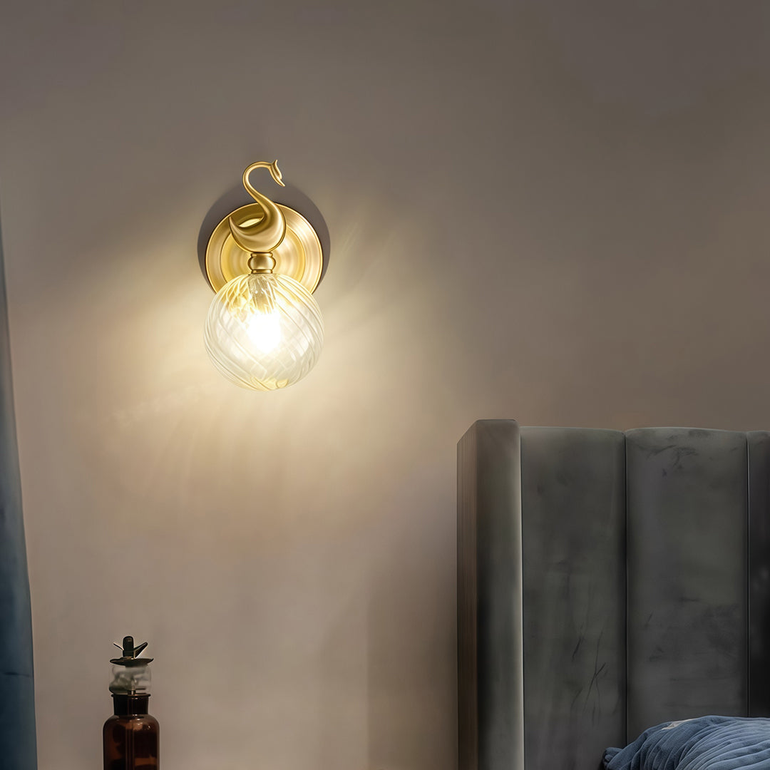 Minimalist wall mounted LED light featuring glass shade chandelier design creating warm glow on neutral accent wall.