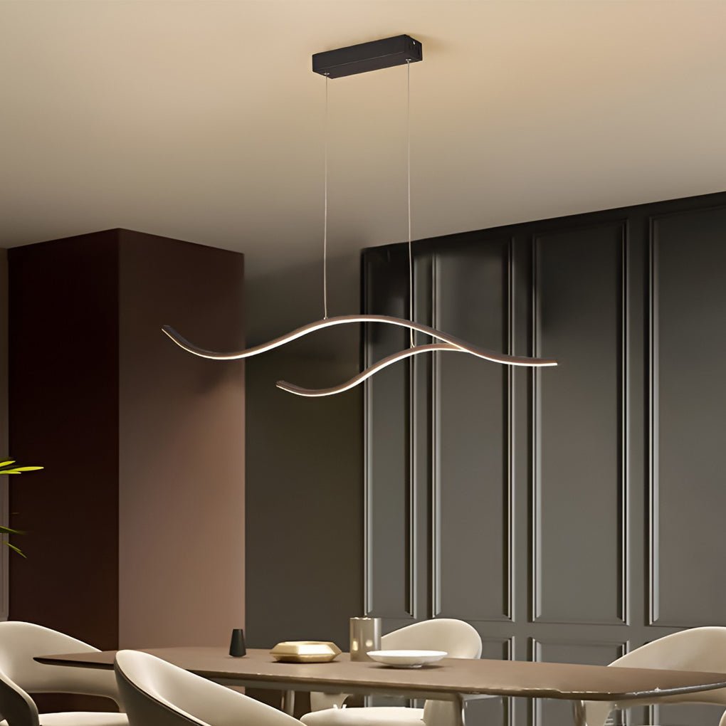 Minimalist wave curved LED pendant light hanging above a modern dining area with neutral tones.