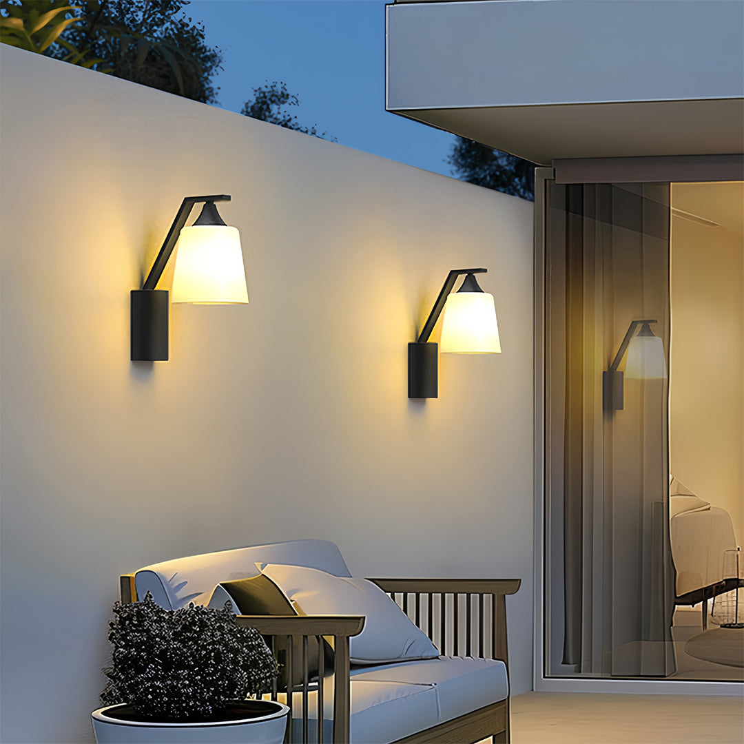 Outdoor sconce light with a minimalist design, featuring a white shade and black frame, adding sophistication to outdoor areas.