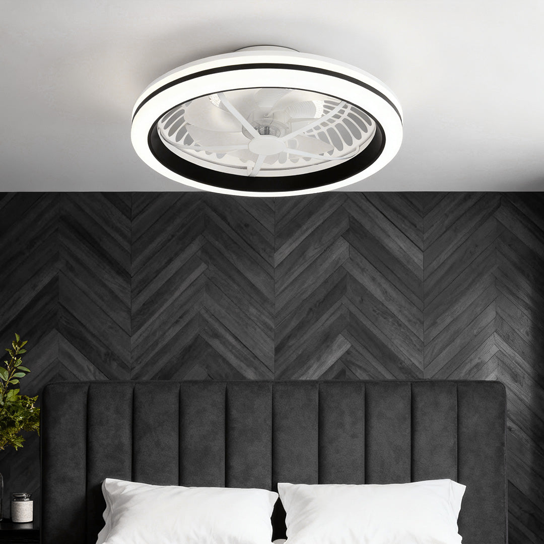 Minimalist black-accented white flush mount ceiling fan with light installed in a chic bedroom with a black chevron headboard. 