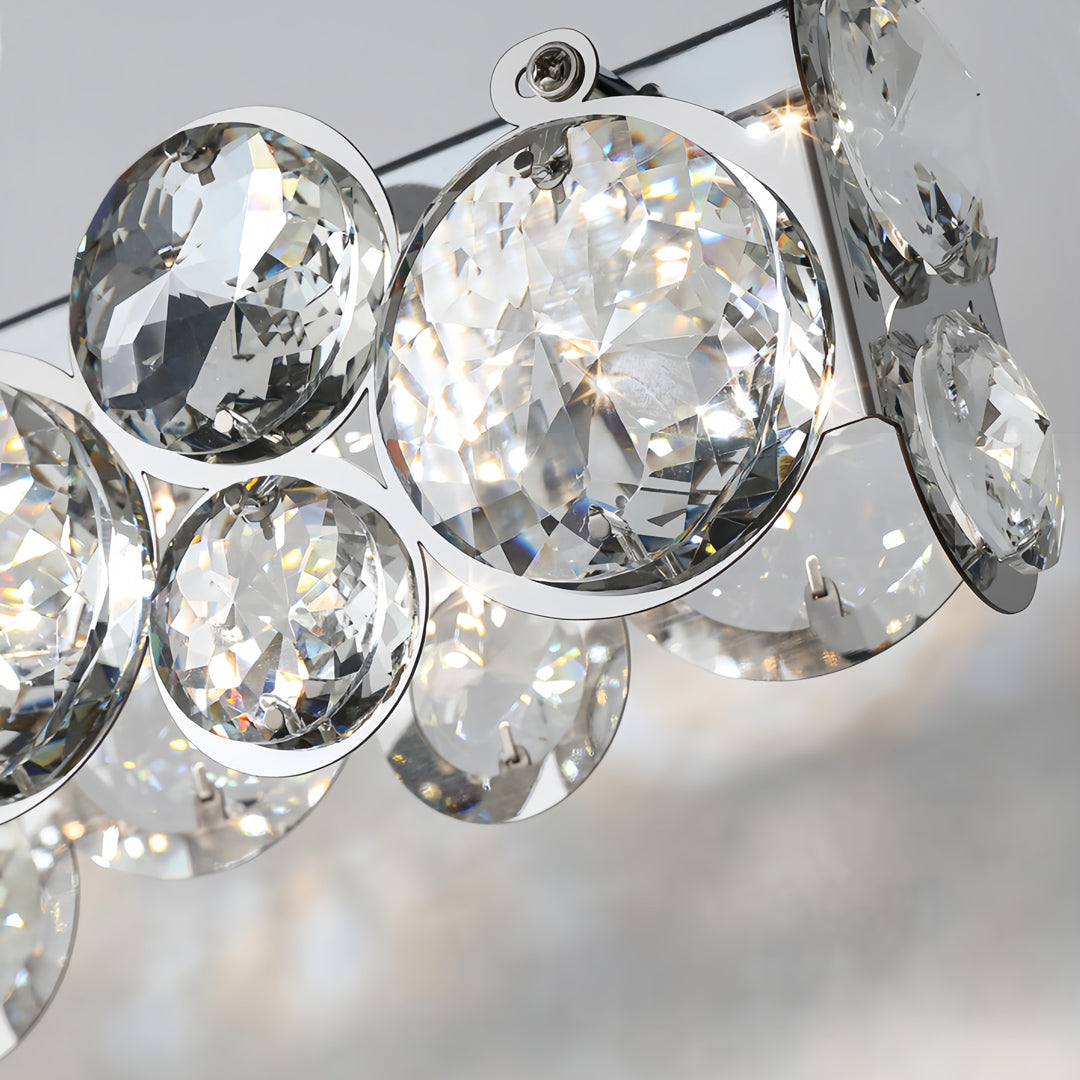 Minimalist white finish S-wave LED silver pendant light hanging over a contemporary table in a bright room.