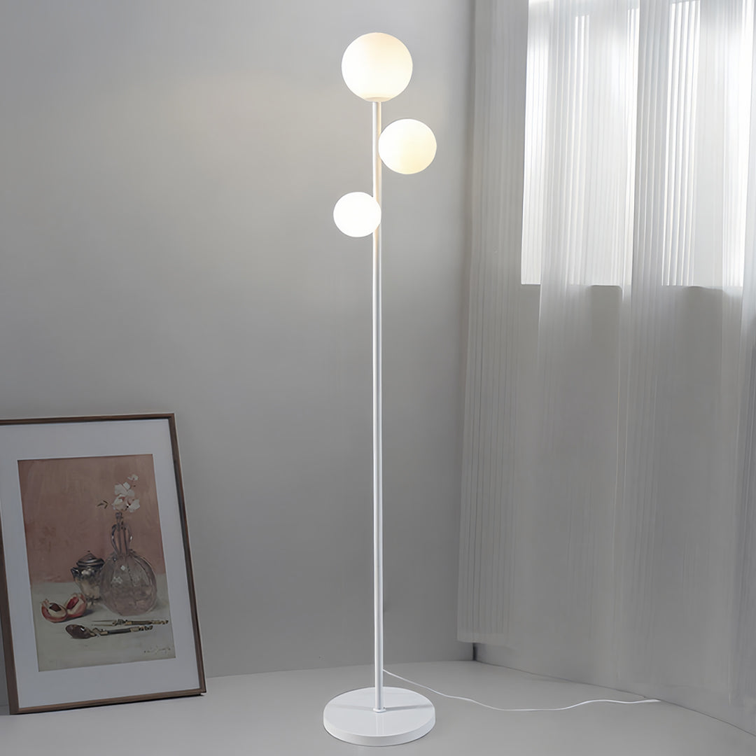 Modern 3 lights floor lamp with black pole and white spherical shades providing elegant room illumination