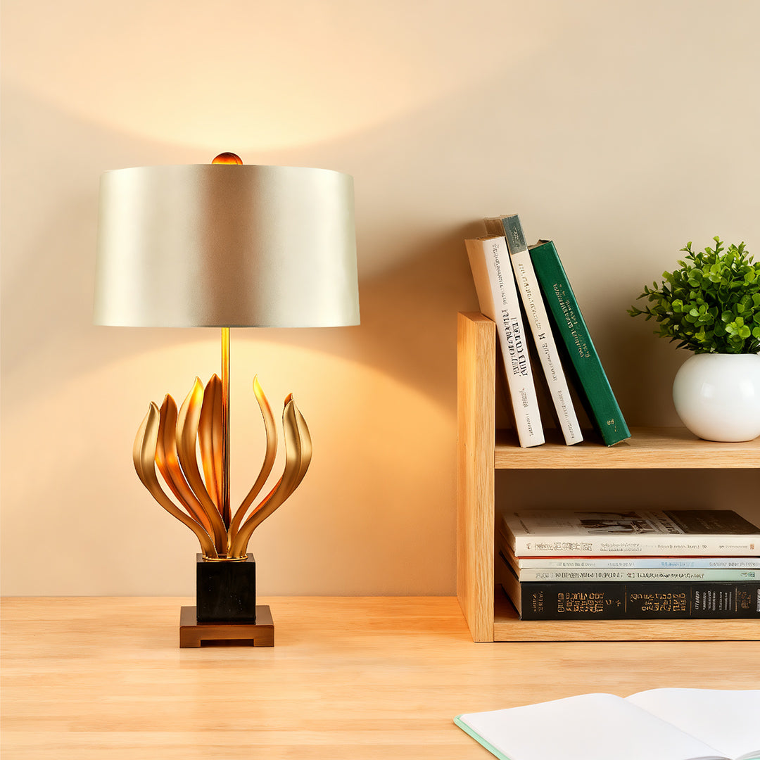 Vintage gold metal table lamp with sculptural base and beige lampshade in a chic living room