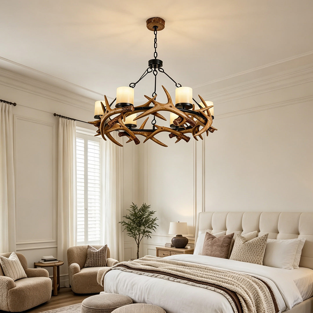 Modern antler chandelier installed in a cozy bedroom with rustic luxury interior styling.