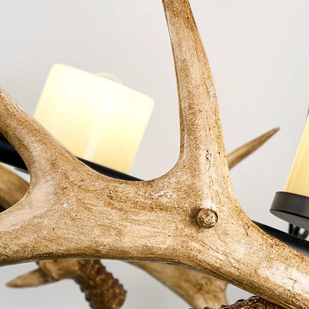Modern antler chandelier close-up showing textured antler frame and candle style bulbs.