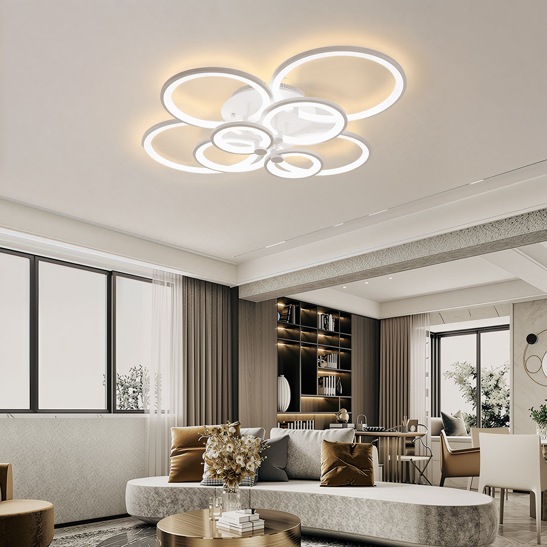 Modern apartment living space featuring stylish white and gold multi ring ceiling lights.