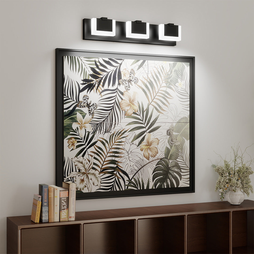 Modern bathroom LED vanity lights featuring glass shade chandelier design installed above dark wood dresser with botanical art.