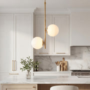 Elegant Vertical Gold Pendant lighting with dual frosted globes in a cozy modern bedroom.