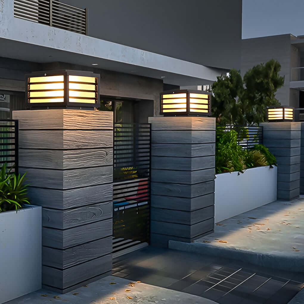 Modern black gate pillar light with a rectangular shape, installed on a stone pillar for sophisticated outdoor ambiance.