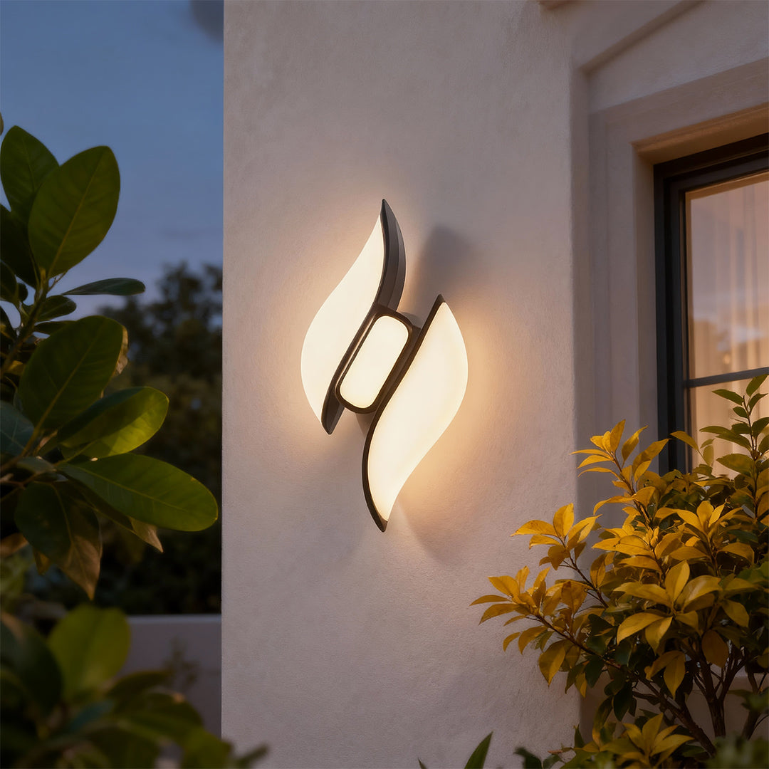 Modern black outdoor wall sconces featuring glass shade chandelier styling creating warm ambient glow on contemporary patio wall.