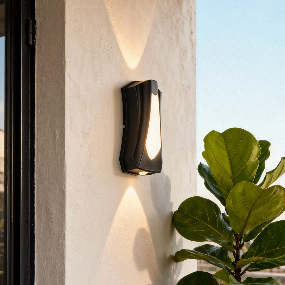 Modern black outside up down wall lights mounted on a white exterior wall, casting symmetrical light beams.