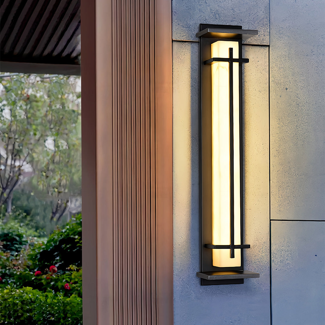 Modern black outside wall lights illuminating a concrete exterior wall next to a wooden entryway.