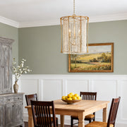 Chic wood beaded chandelier with gold frame in a minimalist dining room with floral centerpiece