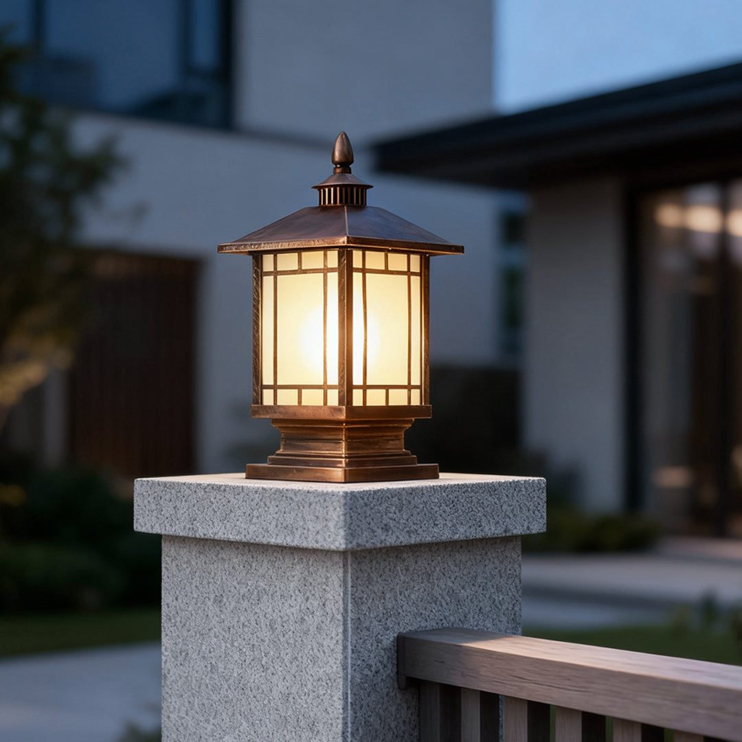 Modern black street light pillar mounted on stone column in residential outdoor setting.