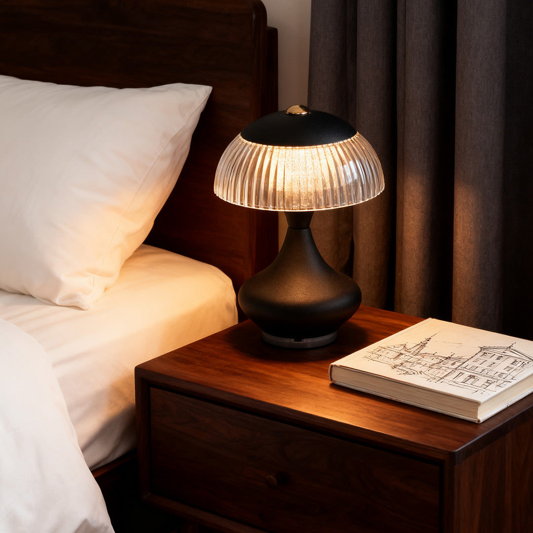 Modern black table unique lamps creating a soft, ambient glow on a dark wooden nightstand in a bedroom.
