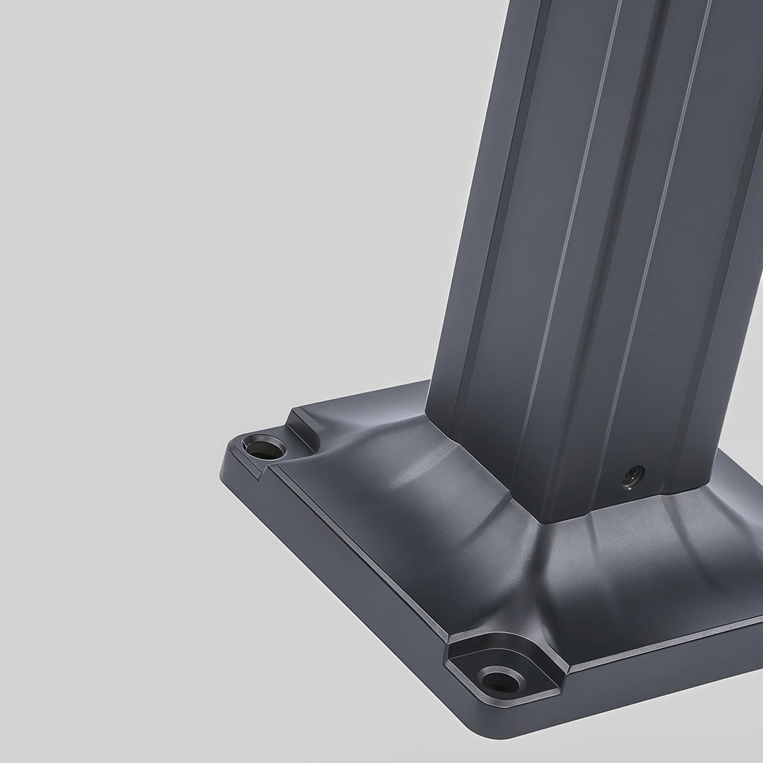 Modern black wall light with a strong, focused beam, mounted on a stone pillar at night.