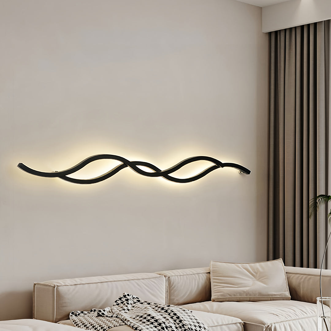 Modern black wavy bedside wall light fixture providing soft accent lighting in a minimalist bedroom setting.