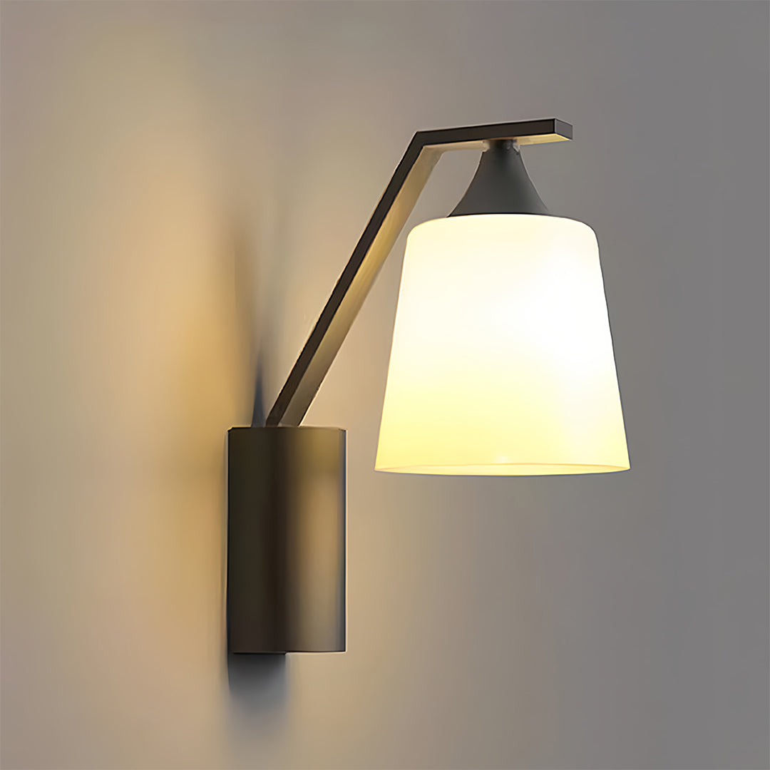 Modern black outdoor sconce with a white shade, designed to provide a soft glow and stylish look for exterior walls.