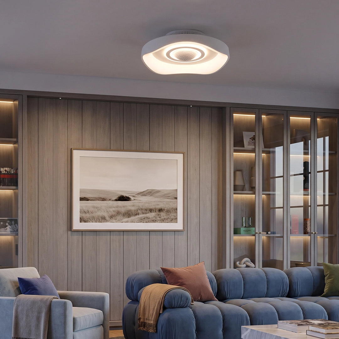 Modern bladeless fan with light installed on a living room ceiling, featuring a sculptural white design and warm integrated LED illumination.