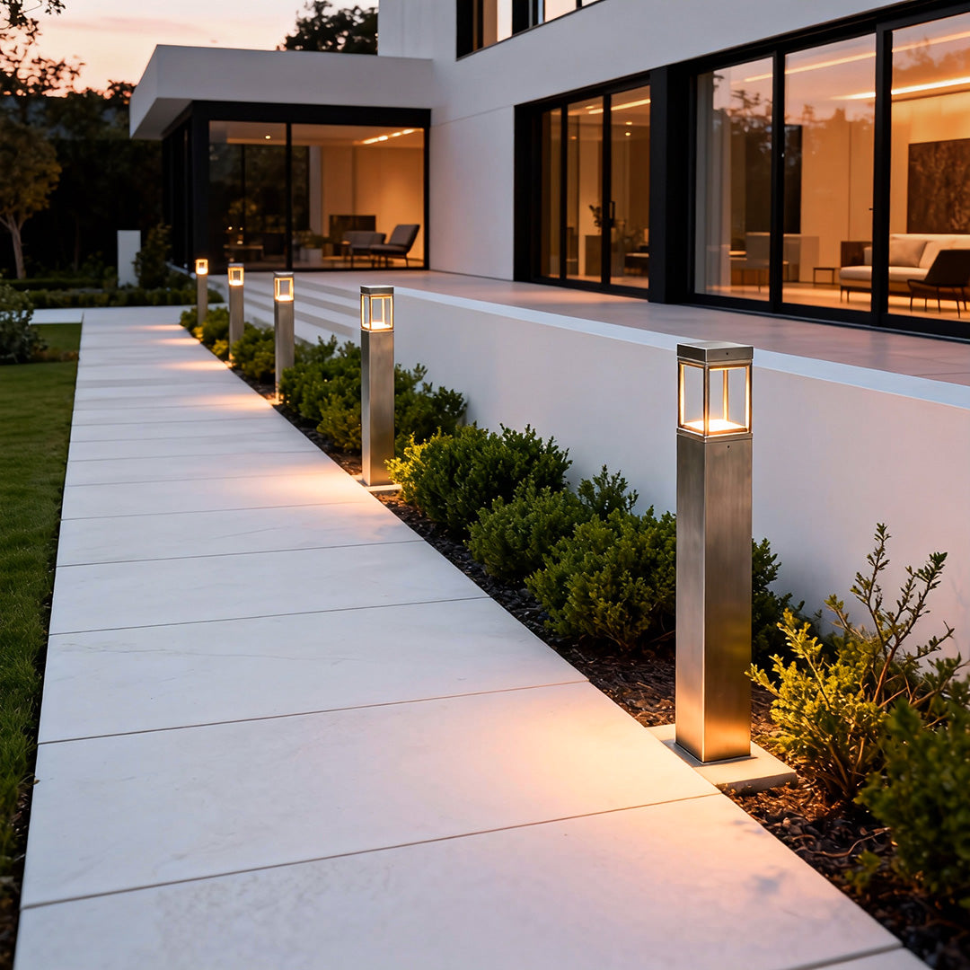 Modern bollard light used beside a paved pathway near a building entrance, enhancing safety and modern exterior design.