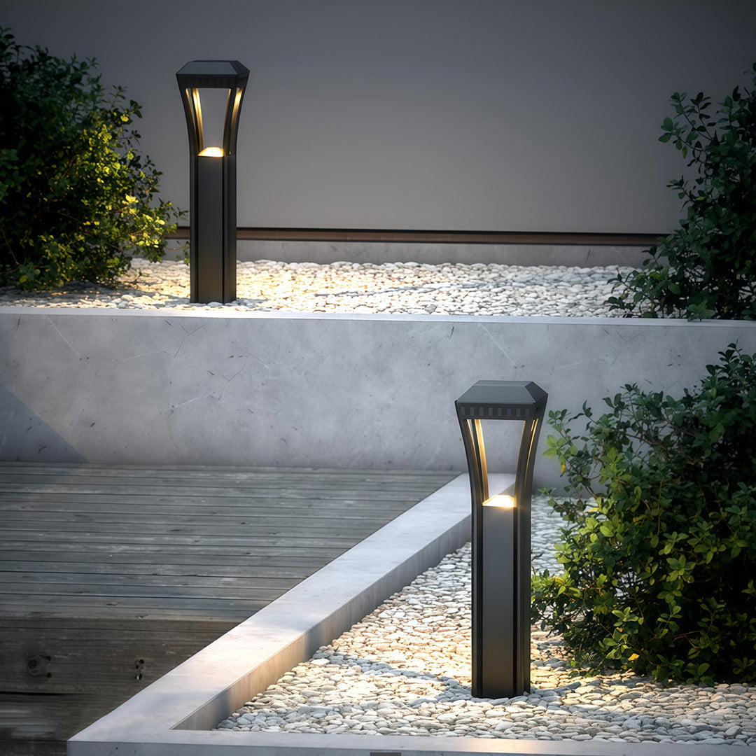 Modern bollard light installed near a building entrance, offering a welcoming and functional glow.