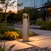 Modern bollard light installed along a landscaped garden path, providing subtle illumination and a sleek architectural look.
