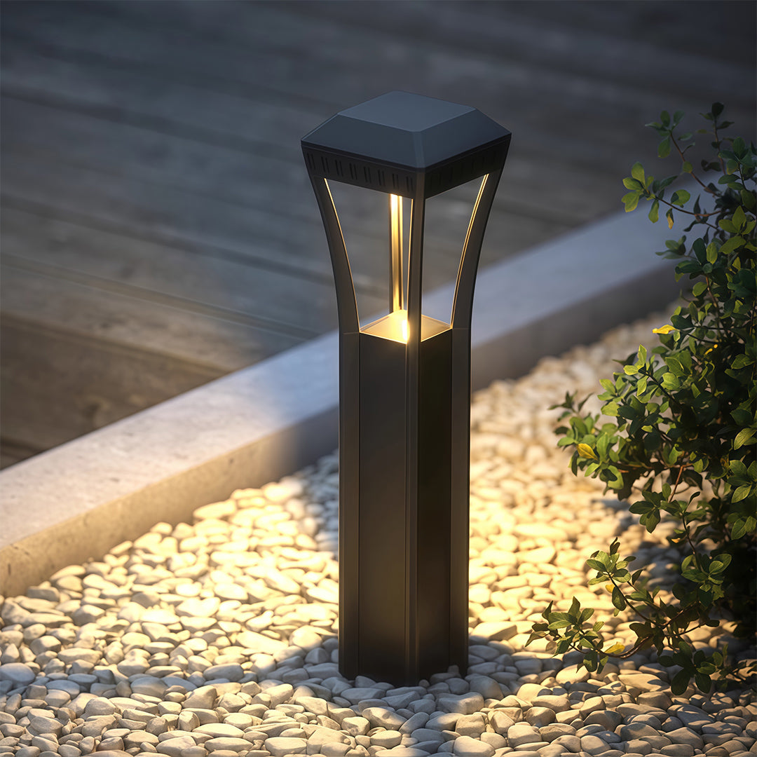 Modern bollard light along a gravel pathway, enhancing the outdoor space with subtle lighting.