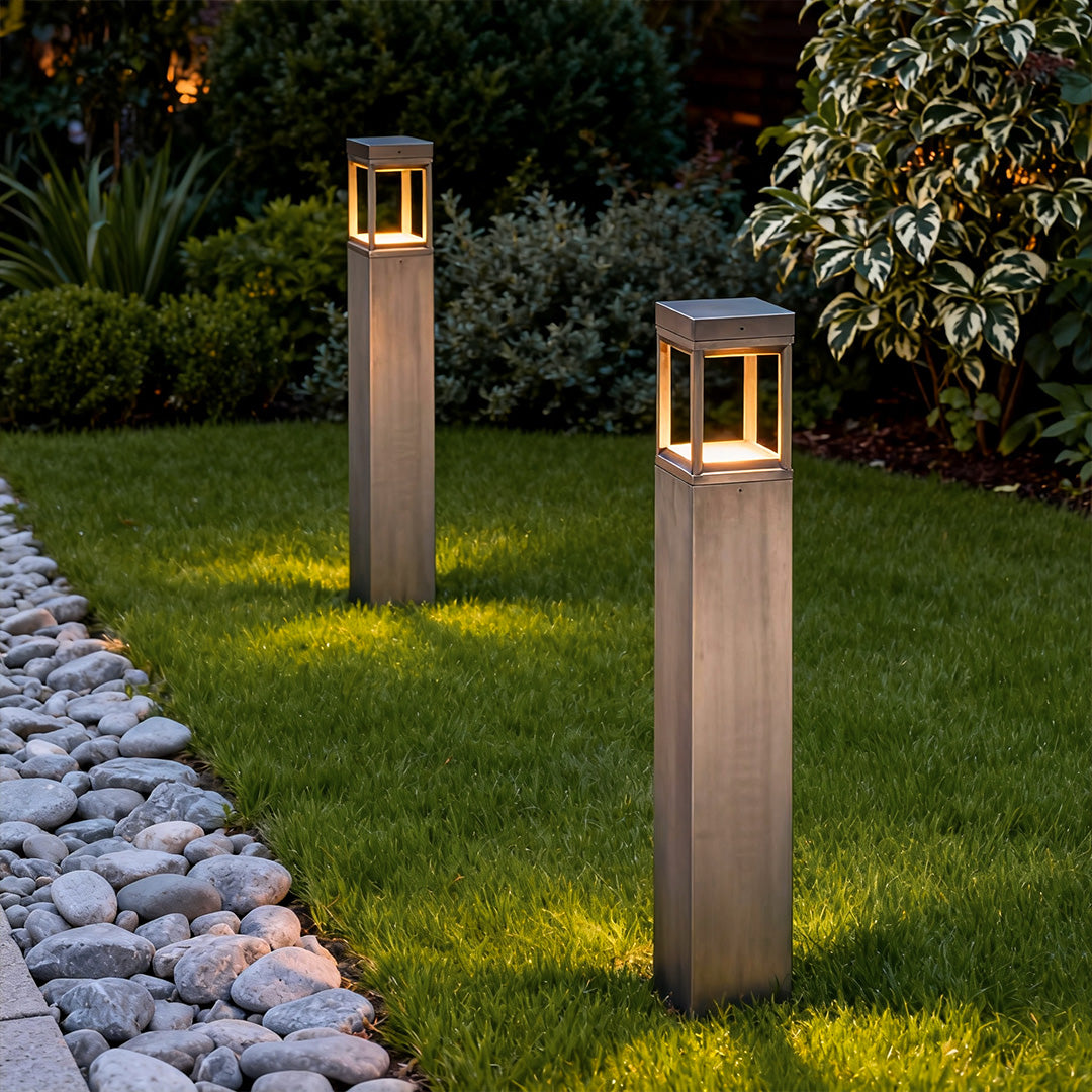 Modern bollard light illuminating a landscaped lawn edge, blending clean design with functional outdoor lighting.