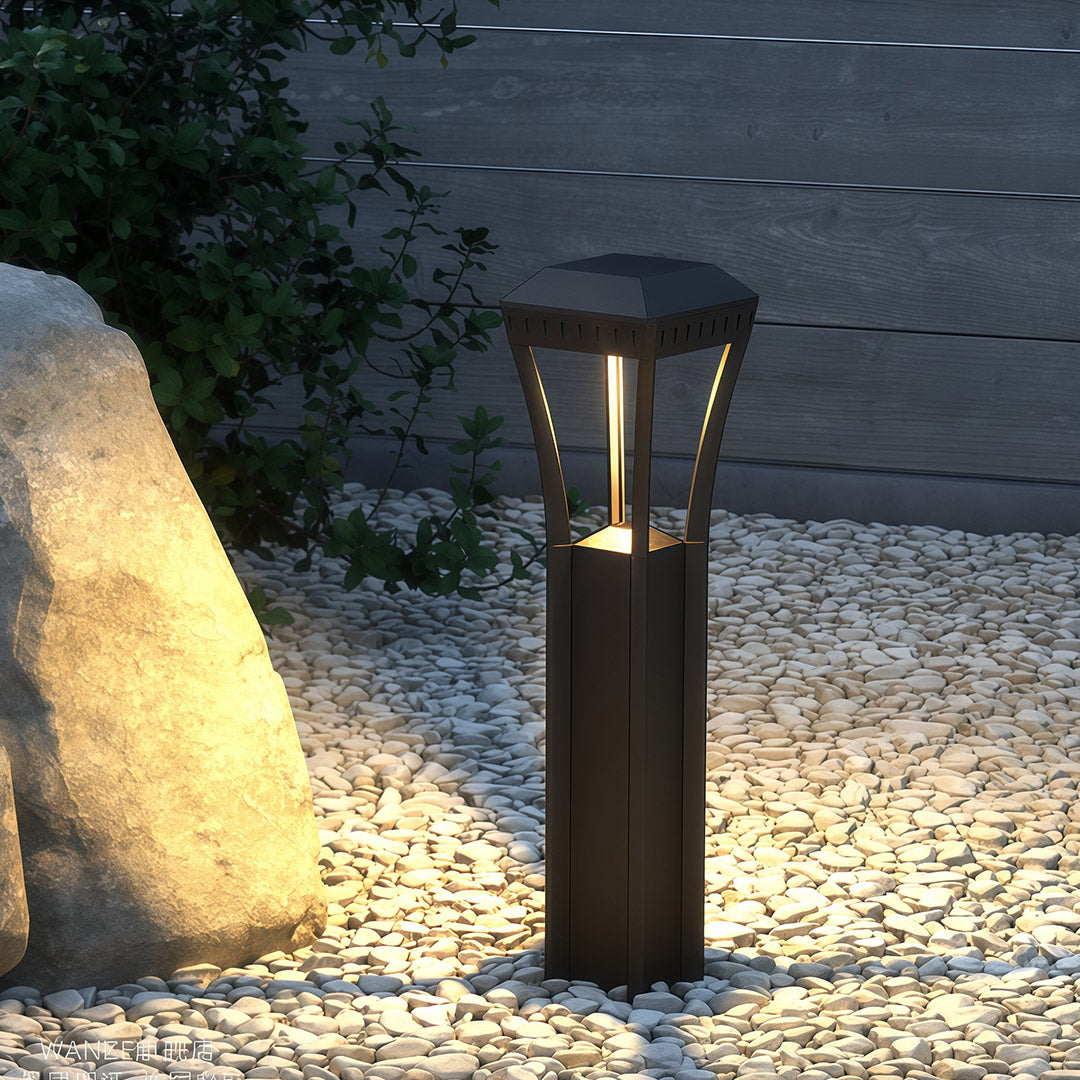 Modern bollard light in an outdoor setting, showcasing its sleek design and warm light.