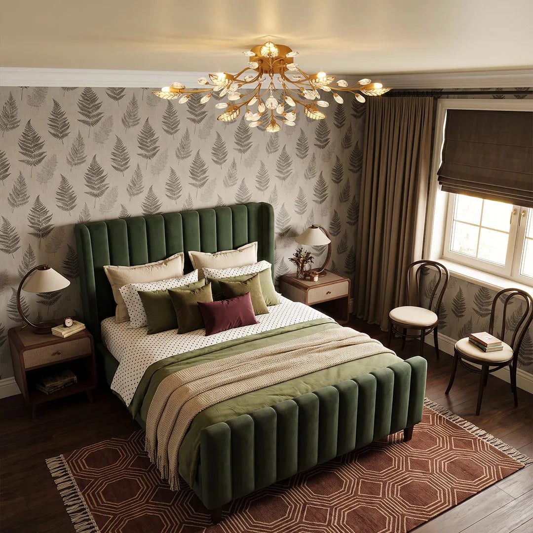 Modern branch chandelier with gold leaf arms and crystal accents installed above a bed in a stylish bedroom.