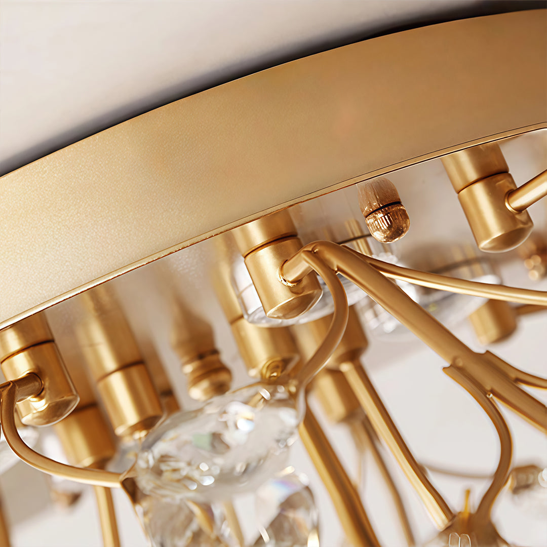 Close-up detail of the modern branch chandelier canopy, gold metal arms, and hanging crystal accents.