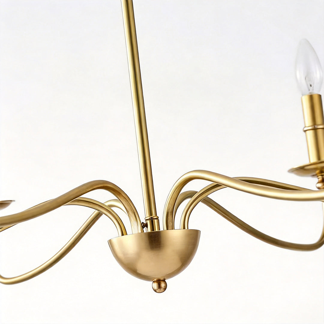 Modern brass chandelier detail showing smooth brass arm structure and candle-style bulb holders.