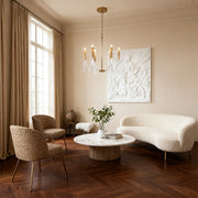Modern transitional acrylic chandeliers with a brass frame and clear block accents, illuminating a stylish living room with textured furniture.
