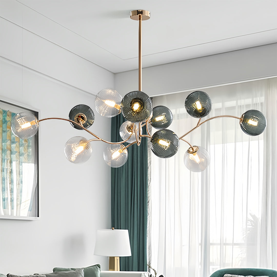 Modern brass chandelier with multiple smoky and clear glass bulbs, installed as a flush mount ceiling light in a dining room.