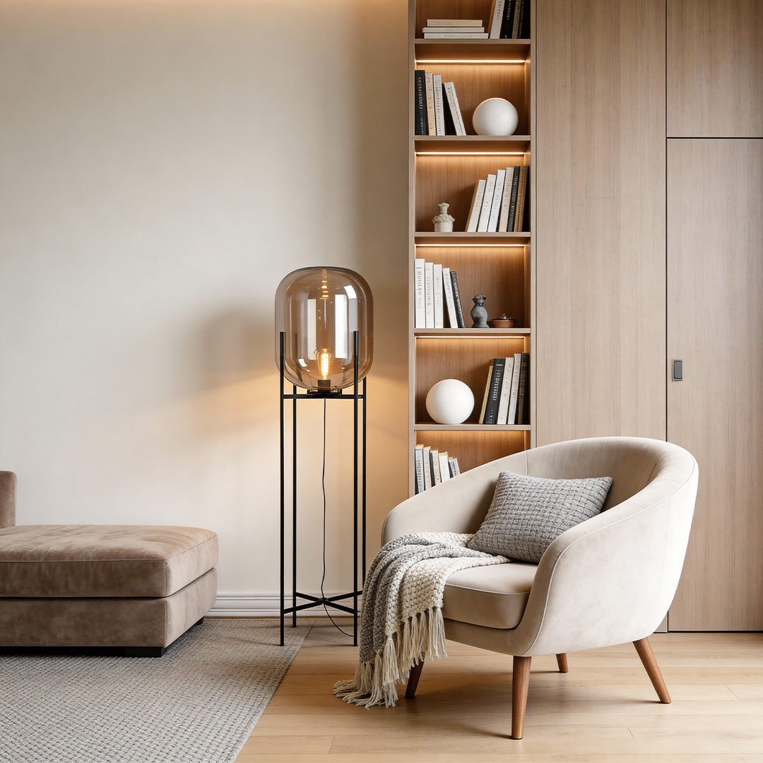 Modern bubble glass floor lamp illuminating a cozy living room with a white armchair and bookshelf.