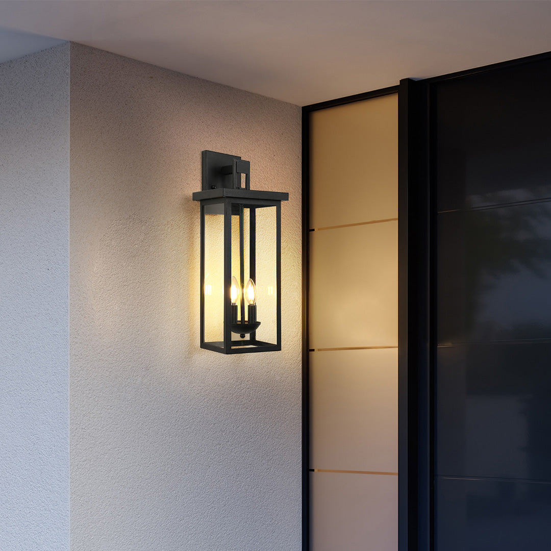 Black external wall light mounted beside a modern building entrance, providing sleek and functional illumination.