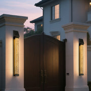Black outdoor lighting sconce with a textured glass front, enhancing the exterior of a modern building.